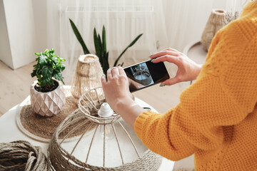 Woman diy blogger takes a photo on a mobile phone for diy blog in social media handmade jute rope...