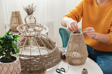 Woman makes handmade diy lamp from jute rope