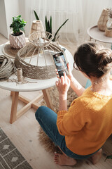 Woman diy blogger takes a photo on a mobile phone for diy blog in social media handmade jute rope...