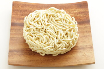 Dried round shaped instant noodles on wooden plate