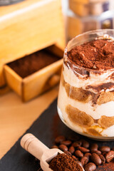 Tiramisu espresso coffee ladyfinger Italian traditional food sweet dessert homemade bakery in glass with beans short grinder	