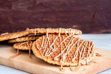 Traditional local authentic Dutch Netherlands sweet fresh homemade tasty stack brown golden waffle melt salted caramel honey syrup for dessert in cafe with hot warm coffee milk tea call Stroopwafel