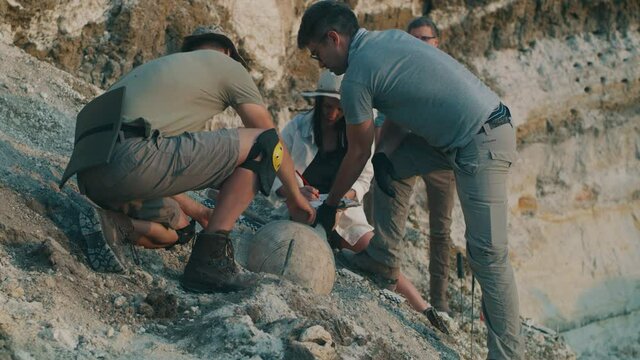 Team of archaeologists excavating amphora