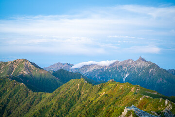 Fototapeta premium 燕岳頂上付近の山荘から見る朝日が当たる槍ヶ岳の風景 A view of Mt. Yarigatake in the morning sun from the mountain lodge near the top of Mt. Tsubakuro.