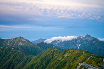Fototapeta premium 燕岳頂上付近の山荘から見る朝日が当たる槍ヶ岳の風景 A view of Mt. Yarigatake in the morning sun from the mountain lodge near the top of Mt. Tsubakuro.