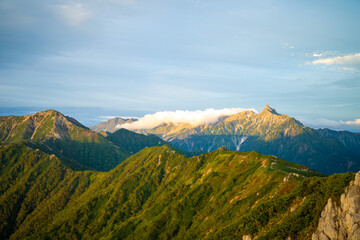 Obraz na płótnie Canvas 燕岳頂上付近の山荘から見る朝日が当たる槍ヶ岳の風景 A view of Mt. Yarigatake in the morning sun from the mountain lodge near the top of Mt. Tsubakuro.