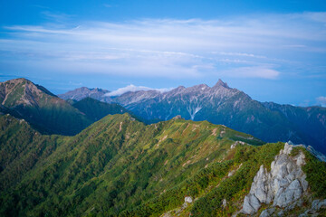 Fototapeta premium 燕岳頂上付近の山荘から見る朝日が当たる槍ヶ岳の風景 A view of Mt. Yarigatake in the morning sun from the mountain lodge near the top of Mt. Tsubakuro.