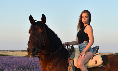 Obraz premium a blonde model riding a horse in a lavender field