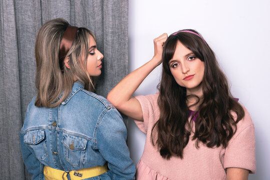 2 mujeres posan juntas luciendo su indumentaria juvenil