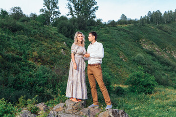 Romantic inloved couple standing on rocks by the river.