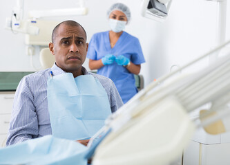 Fototapeta premium Patient is afraid to have his teeth treated at the dentist