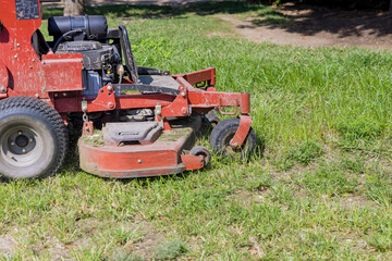 Obraz premium Utility worker in lawn mower gardener cutting the grass ride-on lawnmower