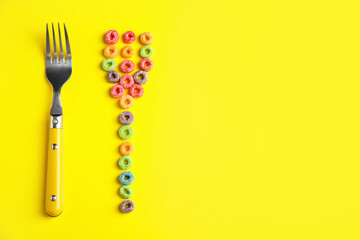 Creative composition with cereal rings and fork on color background