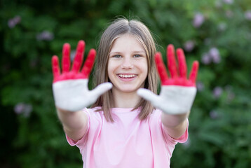 Child girl show hands painted in Indonesia flag colors. Indonesian patriotism concept. Indonesian Independence Day, Hari Kemerdekaan Indonesia, 17 August. National Day of Monaco 19 November