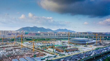Fototapeta premium Huge Stadium construction site near the road and mountain for Olympics, Hangzhou, China