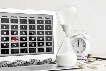 Hourglass, alarm clock and laptop with calendar on light background. Deadline concept