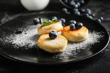 Plate with tasty cottage cheese pancakes and blueberry on table