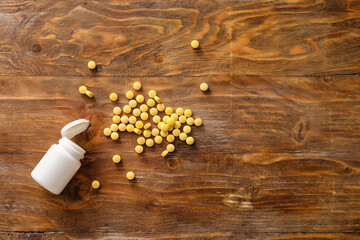 Bottle with vitamin A pills on wooden background