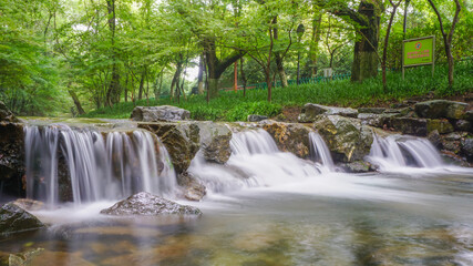 Waterfall and blue stream in the forest nature background for design, China