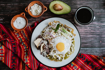 mexican chilaquiles with fried egg, chicken and spicy green sauce traditional breakfast in Mexico