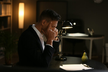 Depressed young businessman in office late in evening