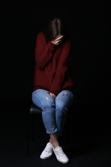 Scared young woman on dark background. Concept of harassment