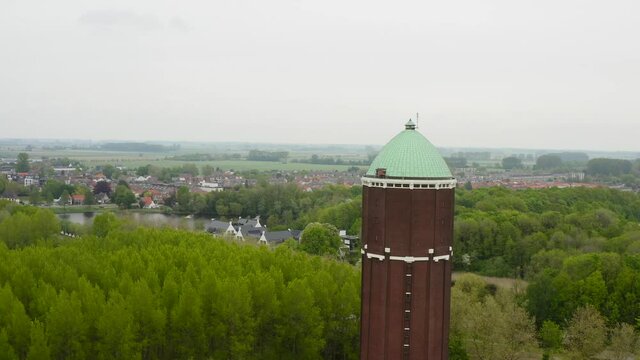 Aerial Revealing Shot Of The Famous Water Tower In The City Of Axel Shot On A Cloudy Day With City Panorama