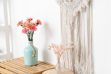 Vase with beautiful carnations on table in room