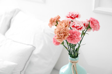 Vase with beautiful carnations in bedroom