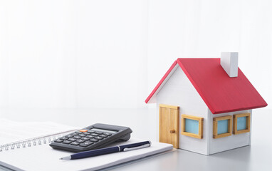 Housing finance. Calculator, notebook and miniature house.