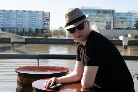 Close-up of an albino man wearing a hat while sitting at a bar.