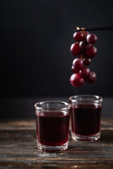 Red grape juice in a glass on wooden with hanging grape, Healthy drink, Still Life