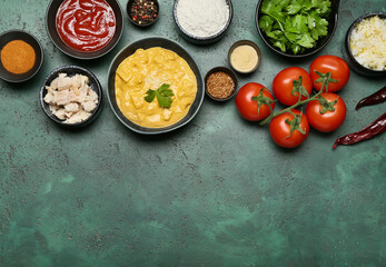 Bowl of tasty chicken curry and ingredients on color background