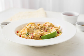 Plate of tasty chicken curry on table