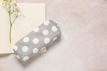 Stylish pencil case and notebook on light background