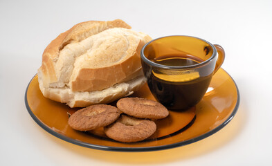 French bread with margarine, coffee cup and cookies on brown plate. Brazilian breakfast.