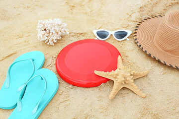 Fototapeta na wymiar Composition with frisbee disk and beach accessories on sand