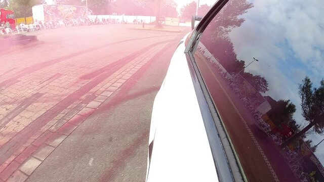 Reflection On Car Window While Drifting And Exhausting Colored Smoke At The Arena. close up