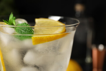 Glass of cold gin and tonic on dark background, closeup