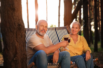 Mature couple drinking wine at barbecue party outdoors