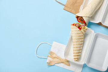Plastic lunch boxes with tasty Fajitas on blue background