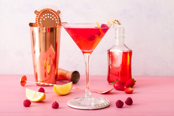 Glass of tasty cosmopolitan cocktail on color wooden background