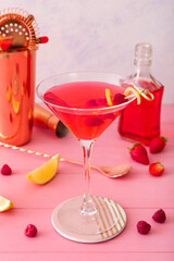 Glass of tasty cosmopolitan cocktail on color wooden background