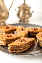 Tray with tasty baklava on light wooden background