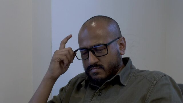 Ethnic Minority Bald Male Wearing Glasses, Finger Tapping Forehead. Static Shot