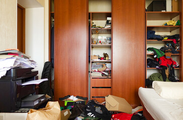 Cluttered room with scattered clothes and boxes. Hoarding or untidiness concept - obrazy, fototapety, plakaty