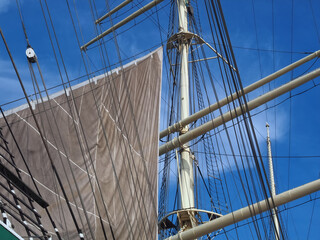 Obraz premium Closeup of sails and ropes of a sailing ship with blue sky