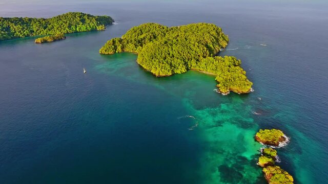 Forward Aerial towards Green Jungle Island Point Revealing Coral Reef Structure