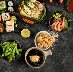 Japanese dishes and snacks on gray background.