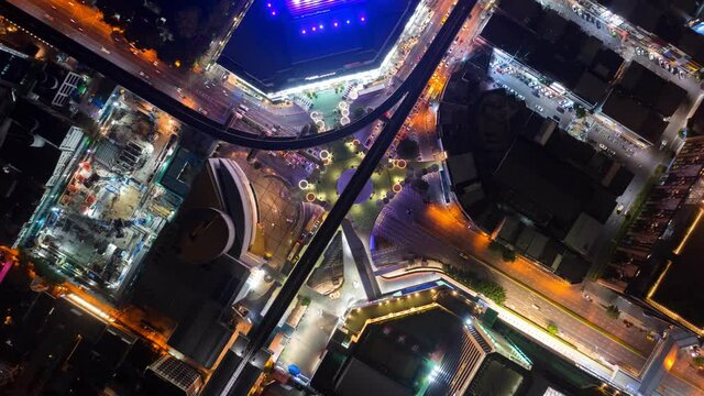 Time lapse of aerial view of Siam Bangkok Art and Skywalk aerial view in MBK Culture Center intersection or junction with cars traffic skyscraper buildings. Bangkok City in downtown at night, Thailand